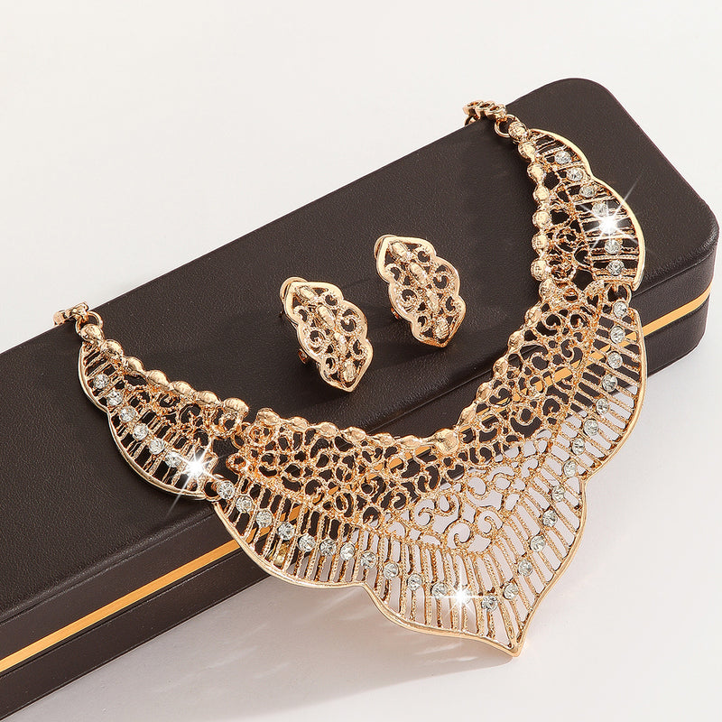 Luxury gold crystal necklace and earrings set displayed on a black jewelry box with sparkling rhinestone details