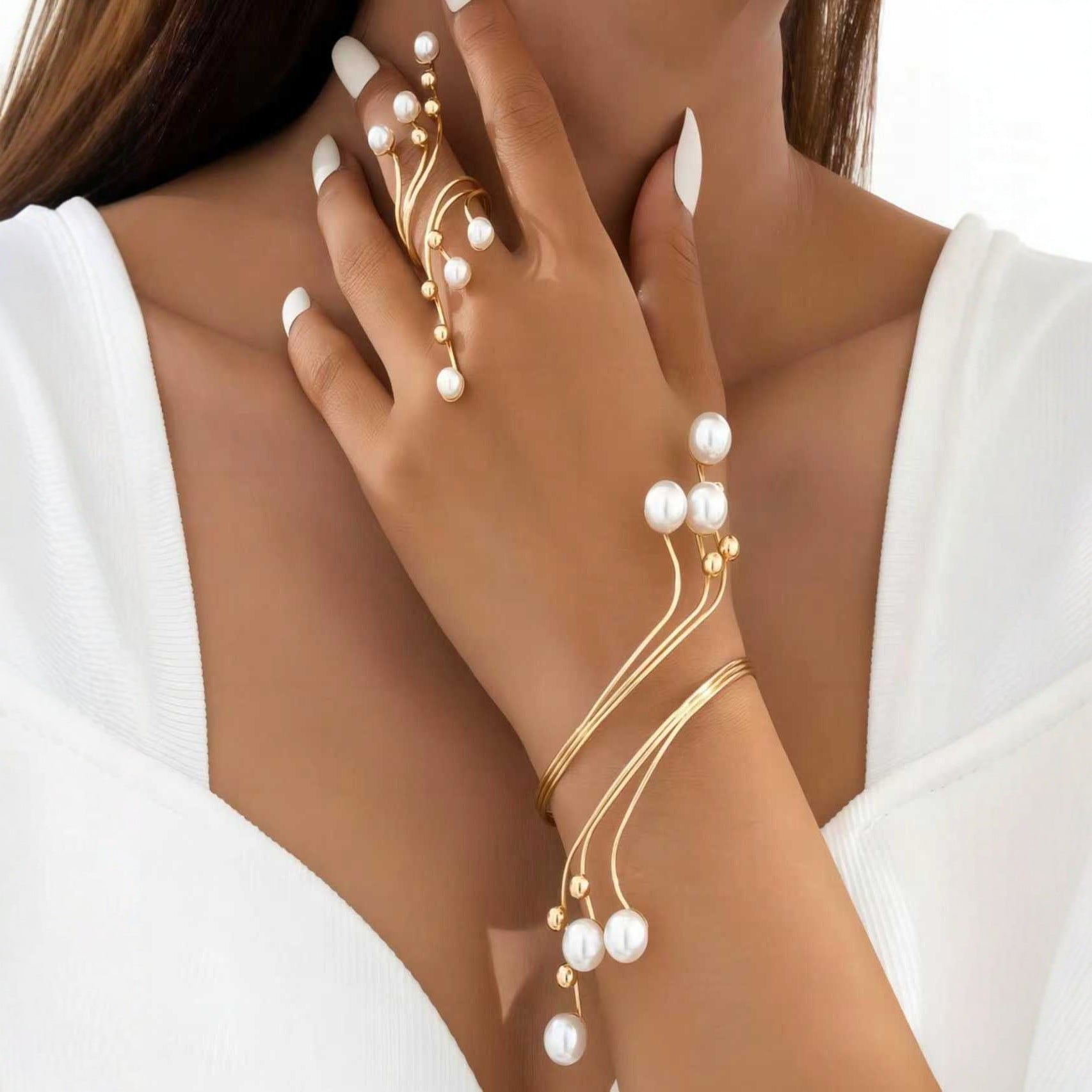 Gold-tone pearl hand chain bracelet for women with elegant flowing wire design