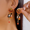 Halloween-themed earrings with jack-o'-lantern design worn by a person.