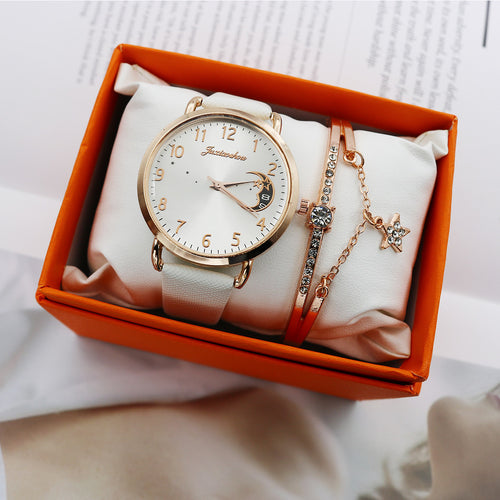 White celestial moon quartz watch with a gold-tone case, matching crystal bracelet and orange presentation box.